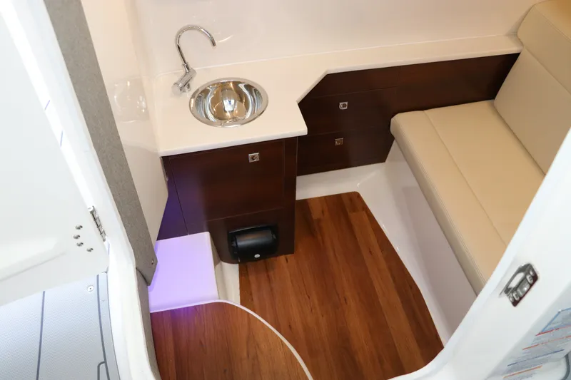 Slide: The Image of Interior of 2026 Chaparral 280 OSX boat with sink, seating, and wood flooring. - 32