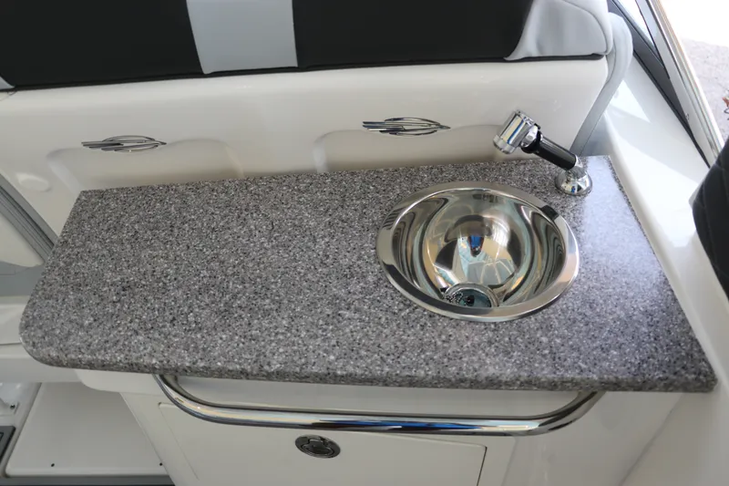 Slide: The Image of Chaparral 280 OSX 2026 boat interior with granite countertop and stainless steel sink. - 18