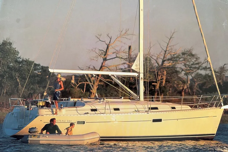 Slide: The Image of 2002 Beneteau Oceanis 361 sailboat on water with people enjoying a sunny day. - 2