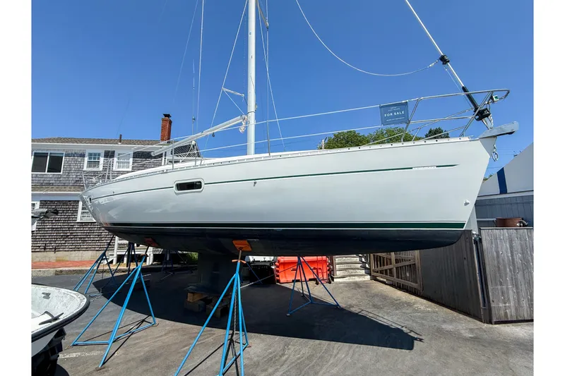 Slide: The Image of 2002 Beneteau Oceanis 361 sailboat on stands, displayed for sale under clear blue sky. - 0
