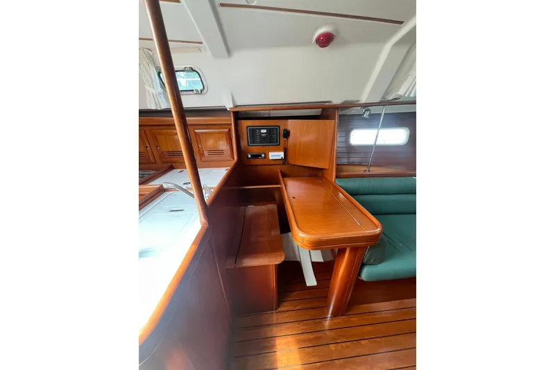 Slide: The Image of Interior of 2002 Beneteau Oceanis 361 sailboat with wooden table and seating area. - 6