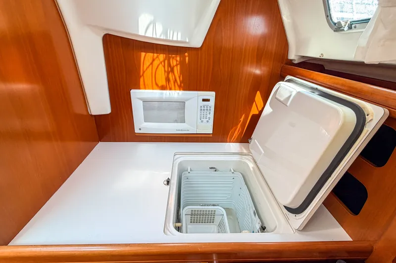 Slide: The Image of Interior of 2002 Beneteau 361 yacht with microwave and open storage compartment. - 14