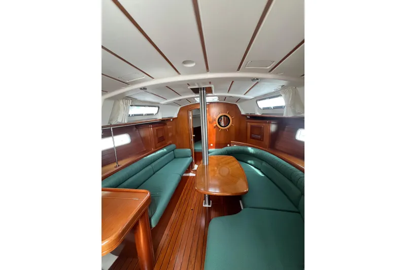 Slide: The Image of Interior of 2002 Beneteau Oceanis 361 sailboat with green seating and wooden finishes. - 8