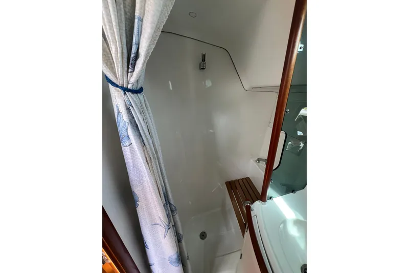 Slide: The Image of Beneteau Oceanis 361 (2002) yacht shower area with curtain and wooden seat. - 11