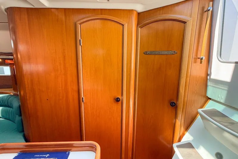 Slide: The Image of Interior of 2002 Beneteau 361 sailboat with wooden doors and cozy cabin design. - 20