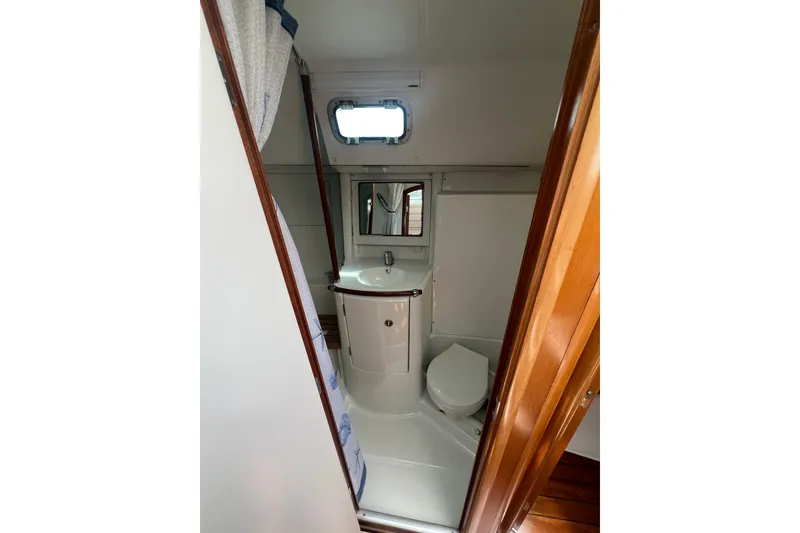 Slide: The Image of Bathroom interior of 2002 Beneteau Oceanis 361 yacht, featuring sink, toilet, and mirror. - 10