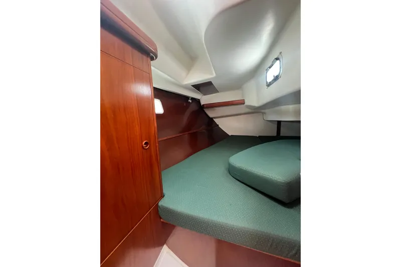 Slide: The Image of Interior cabin of 2002 Beneteau Oceanis 361 sailboat with green cushions and wooden cabinetry. - 12