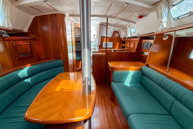 Slide: The Image of Interior of 2002 Beneteau 361 yacht with wood finish and green seating. - 16