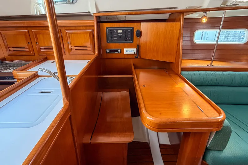 Slide: The Image of 2002 Beneteau 361 yacht interior with wooden cabinetry and navigation station. - 13