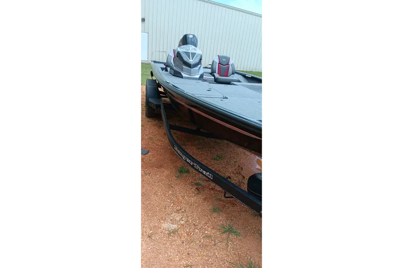 Slide: The Image of 2025 Ranger ALPHA 208 boat on trailer, parked on gravel near a building. - 14