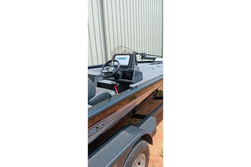 Slide: The Image of 2025 Ranger ALPHA 208 boat interior with steering wheel and console, parked outdoors. - 6
