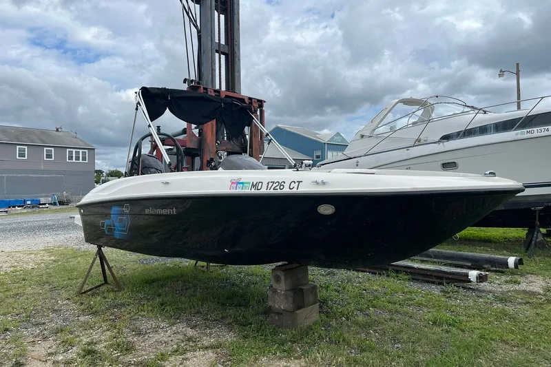 The Image of 2018 Bayliner Element E18 boat on display outdoors, cloudy sky background. - 1