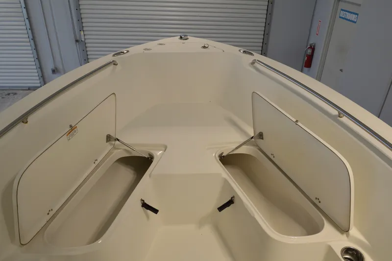 Slide: The Image of 2014 Sailfish 220 CC boat interior with open storage compartments in a garage setting. - 9