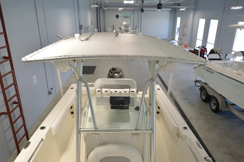 Slide: The Image of 2014 Sailfish 220 CC boat in showroom, featuring T-top and Garmin electronics. - 11