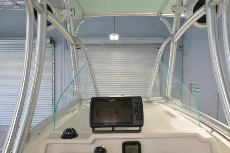 Slide: The Image of 2014 Sailfish 220 CC boat console with navigation equipment in a garage setting. - 3