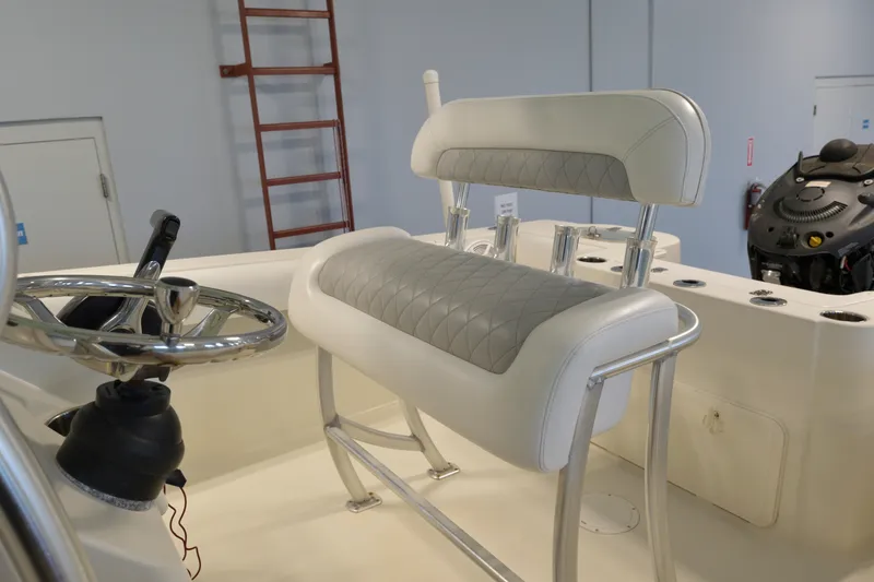 Slide: The Image of 2014 Sailfish 220 CC boat interior with steering wheel and cushioned seating. - 4