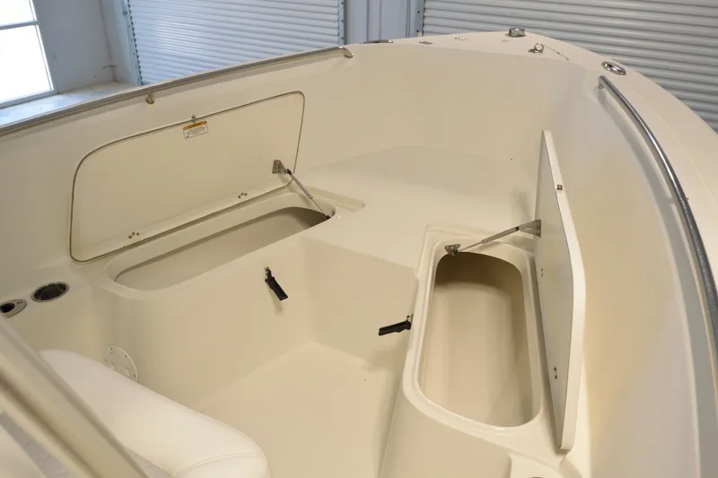 Slide: The Image of 2014 Sailfish 220 CC boat interior with open storage compartments and sleek design. - 10