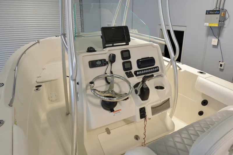 Slide: The Image of 2014 Sailfish 220 CC boat cockpit with steering wheel and navigation equipment. - 2