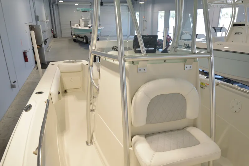 Slide: The Image of 2014 Sailfish 220 CC boat interior with seating and console in showroom. - 12