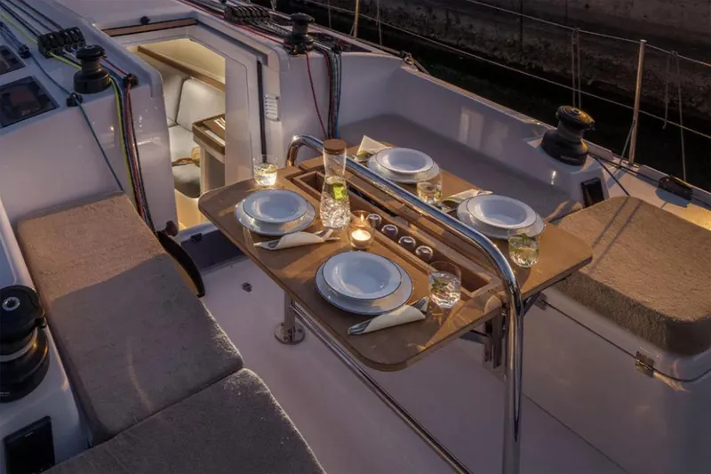 Slide: The Image of Manufacturer Provided Image: Luxurious dining setup on 2026 Beneteau First 36 sailboat deck at dusk. - 3