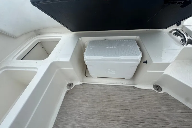 Slide: The Image of 2020 Sea Ray SPX 230 boat interior with storage compartments and cooler. - 45