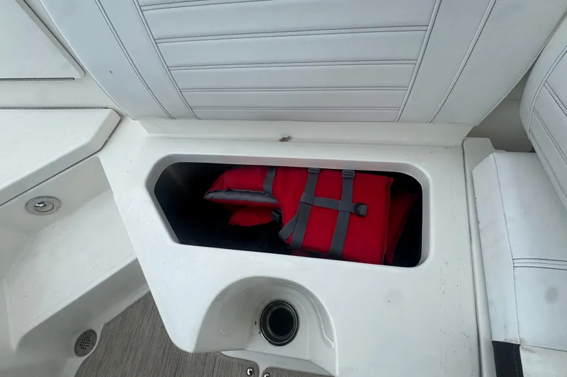 Slide: The Image of Storage compartment with red life jacket on a 2020 Sea Ray SPX 230 boat. - 47