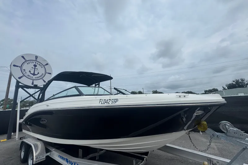 The Image of 2020 Sea Ray SPX 230 boat on trailer under cloudy sky at dealership. - 0
