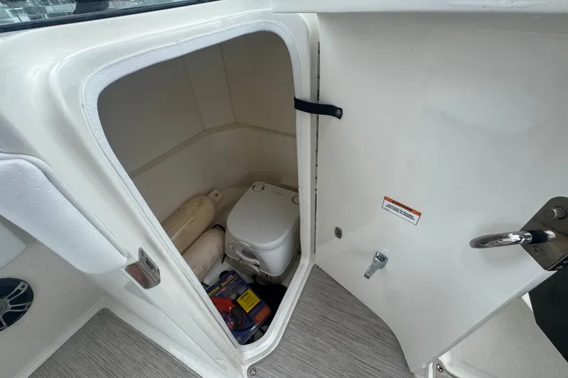 Slide: The Image of 2020 Sea Ray SPX 230 boat interior storage with portable toilet and accessories. - 29