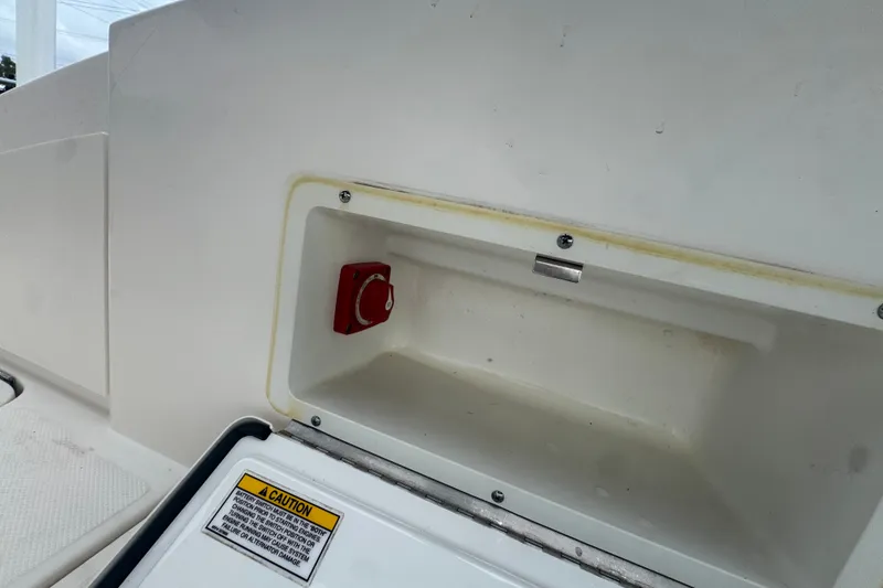 Slide: The Image of 2020 Sea Ray SPX 230 boat compartment with red switch and caution label. - 21
