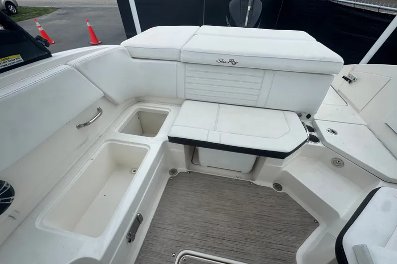 Slide: The Image of 2020 Sea Ray SPX 230 boat interior with white seating and storage compartments. - 44