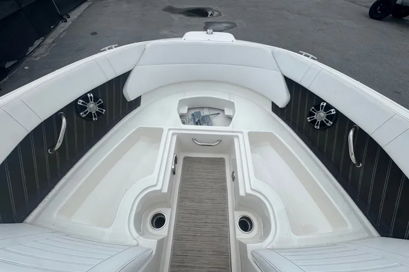 Slide: The Image of Interior view of a 2020 Sea Ray SPX 230 boat, featuring white seating and storage compartments. - 34