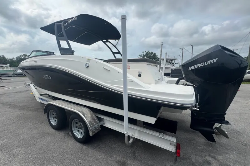 Slide: The Image of 2020 Sea Ray SPX 230 boat on trailer with Mercury outboard motor, parked outdoors. - 9
