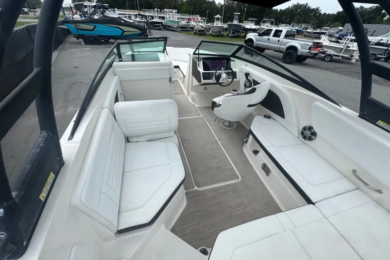 Slide: The Image of 2020 Sea Ray SPX 230 boat interior with white seating and modern dashboard. - 22