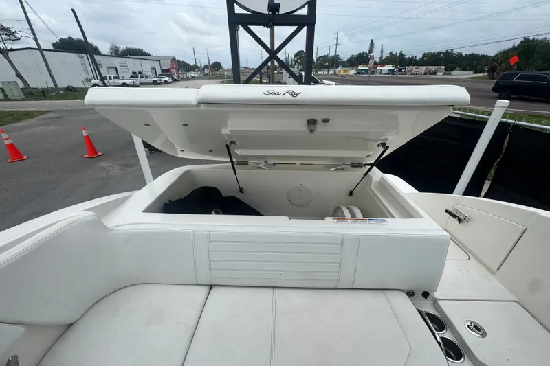 Slide: The Image of 2020 Sea Ray SPX 230 boat with open storage compartment, docked outdoors. - 48