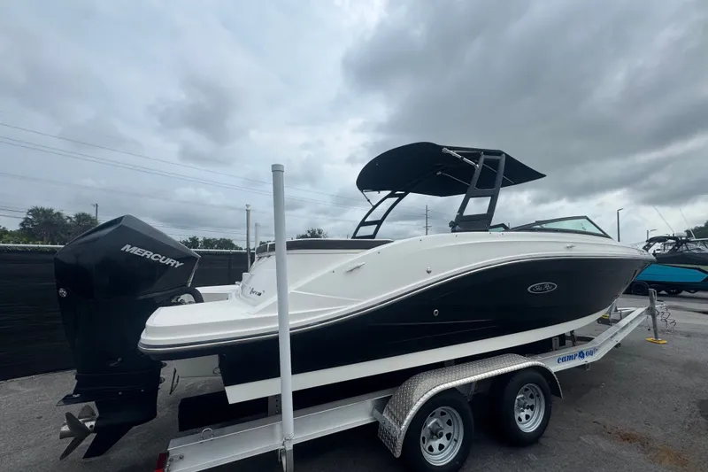 Slide: The Image of 2020 Sea Ray SPX 230 boat on trailer with Mercury outboard motor, under cloudy sky. - 2