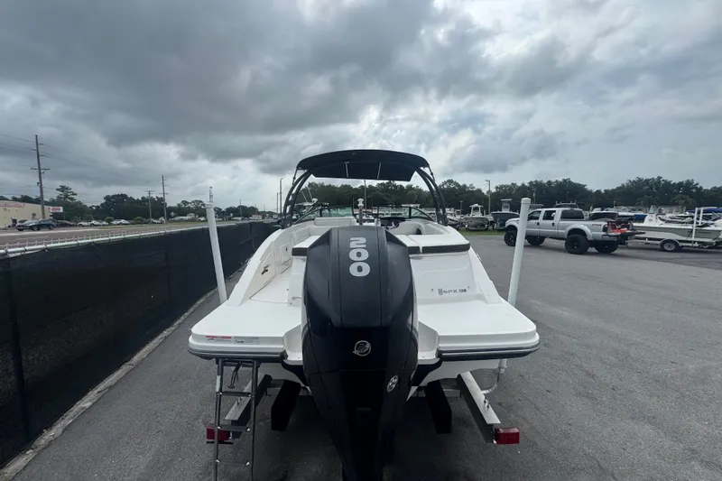 Slide: The Image of 2020 Sea Ray SPX 230 boat with powerful outboard motor, parked under cloudy skies. - 5