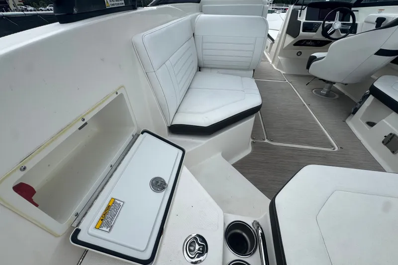 Slide: The Image of 2020 Sea Ray SPX 230 boat interior with white seating and storage compartments. - 20