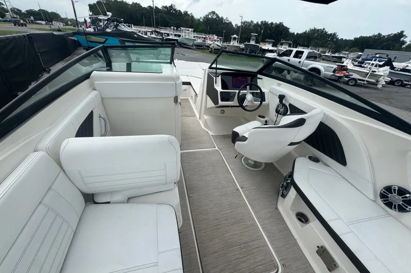 Slide: The Image of 2020 Sea Ray SPX 230 boat interior with white seating and modern dashboard. - 23