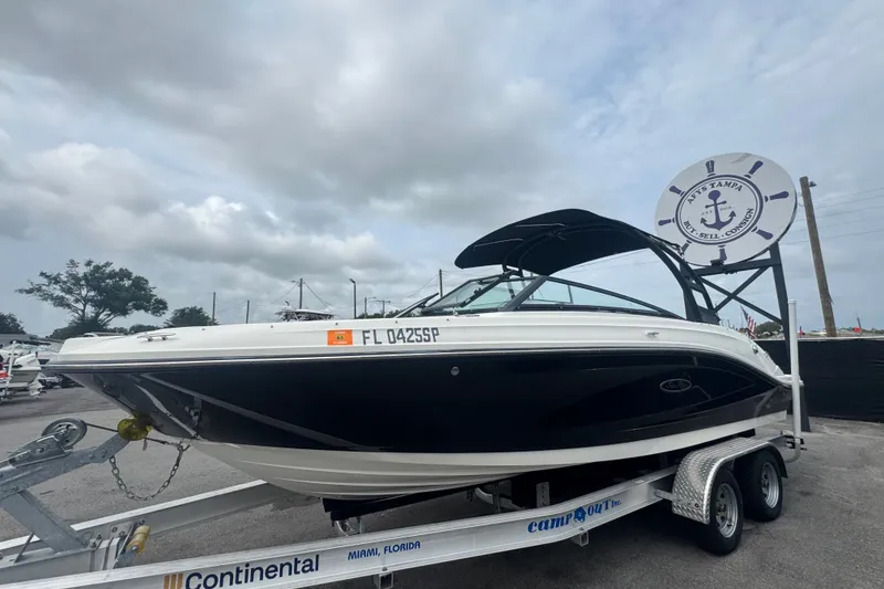 Slide: The Image of 2020 Sea Ray SPX 230 boat on trailer at a dealership under cloudy skies. - 11