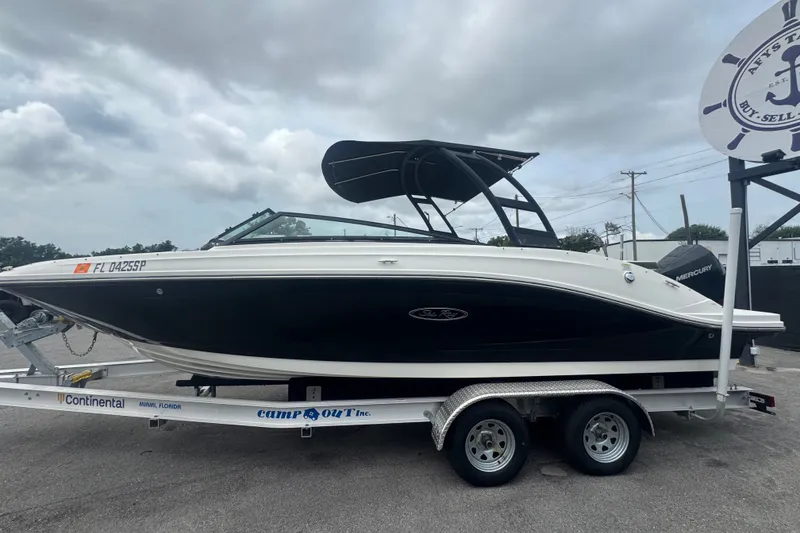 Slide: The Image of 2020 Sea Ray SPX 230 boat on trailer, black hull, overcast sky background. - 10