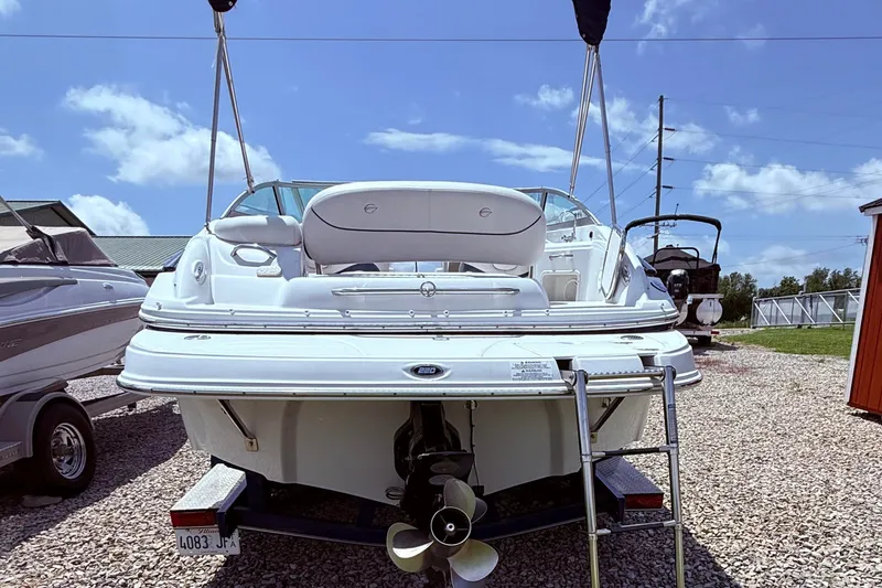 Slide: The Image of 2008 Crownline 220 EX boat with ladder, parked on gravel under a clear blue sky. - 3