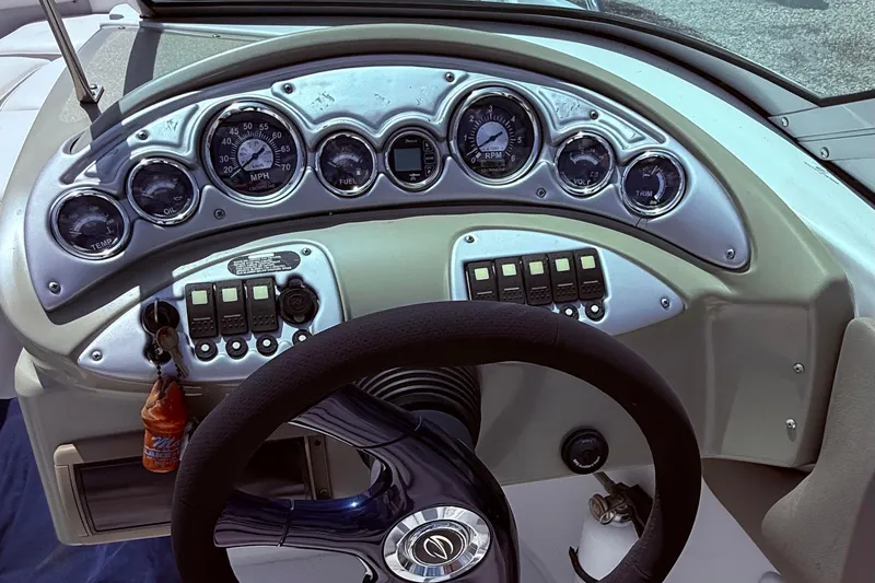 Slide: The Image of Dashboard of a 2008 Crownline 220 EX boat with gauges and steering wheel. - 9