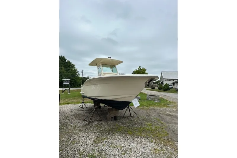 Slide: The Image of 2016 Scout 255 LXF boat on stands, displayed outdoors on gravel. - 3