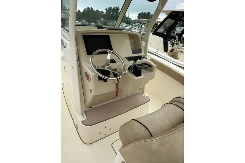Slide: The Image of 2016 Scout 255 LXF boat cockpit with steering wheel and control panel. - 16