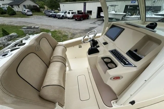 Slide: The Image of 2016 Scout 255 LXF boat interior with beige seating and modern dashboard controls. - 14
