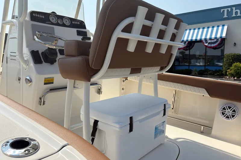 Slide: The Image of 2027 Pioneer 202 Islander boat interior with brown seating and modern dashboard controls. - 13