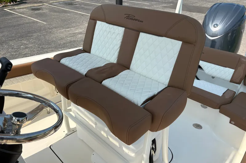Slide: The Image of 2027 Pioneer 202 Islander boat with brown and white cushioned seating. - 17