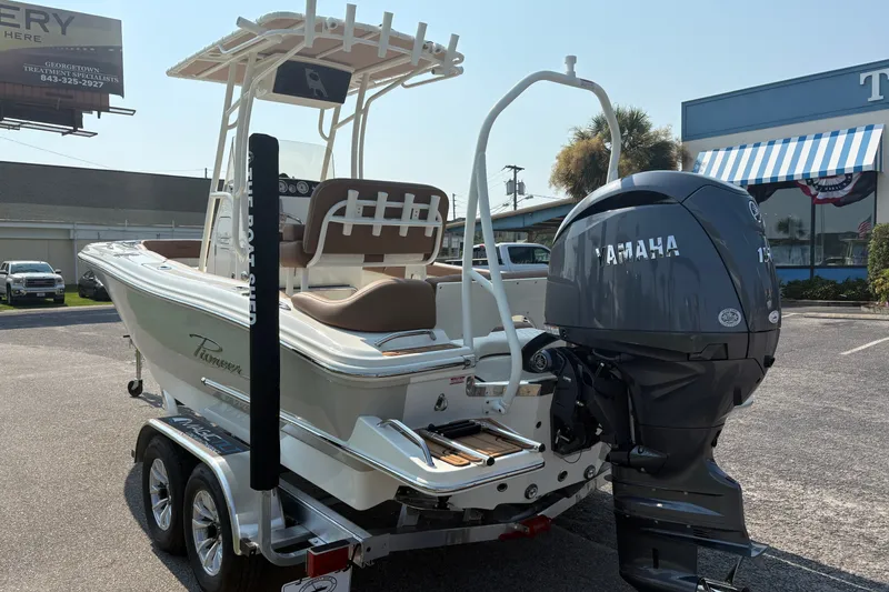 Slide: The Image of 2027 Pioneer 202 Islander boat with Yamaha engine on a trailer in a parking lot. - 1