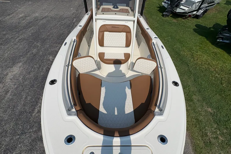 Slide: The Image of 2027 Pioneer 202 Islander boat interior with brown and white seating, docked on grass. - 33