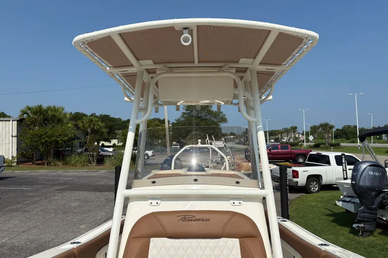 Slide: The Image of 2027 Pioneer 202 Islander boat with T-top, parked outdoors on a sunny day. - 29